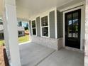 Covered front porch with white columns and a black front door at 29 Riverbirch Ct, Dallas, GA 30157