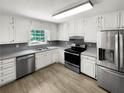 Bright kitchen with stainless steel appliances and white cabinets at 3188 Village Glen Dr, Snellville, GA 30039