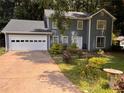 Two-story house with attached garage and landscaped yard at 5025 Cold Springs Nw Dr, Lilburn, GA 30047