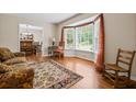 Living room with hardwood floors, bay window, and comfortable seating at 2690 Hideaway Hills Sw Ln, Powder Springs, GA 30127