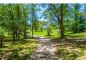 Gravel driveway leading to a charming house surrounded by trees at 3545 Liberty Rd, Villa Rica, GA 30180