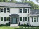 White two story house with dark shutters, gray roof, and stone accents at 4604 Shumart Dr, Snellville, GA 30039