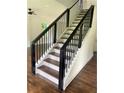 Modern staircase with dark metal railing and wood steps at 4604 Shumart Dr, Snellville, GA 30039