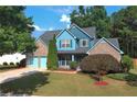 Two-story house with brick and blue siding, a two-car garage, and a lush green lawn at 923 Buckhorn Bnd, Locust Grove, GA 30248