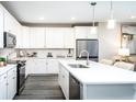 Modern white kitchen with island, stainless steel appliances, and hardwood floors at 3351 Orwell Way # 2104, Cumming, GA 30041