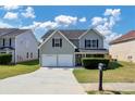 Two-story house with gray siding, two-car garage, and manicured lawn at 5908 Bluegrass Vw, Fairburn, GA 30213