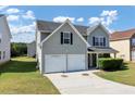 Two-story house with gray siding, two-car garage, and manicured lawn at 5908 Bluegrass Vw, Fairburn, GA 30213