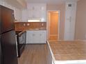 Bright kitchen with white cabinets, black appliances and tile flooring at 1038 Ascot Ct, Riverdale, GA 30296