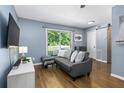 Living room with grey sectional sofa, hardwood floors, and a large TV at 1418 Foxhall Se Ln # 6, Atlanta, GA 30316