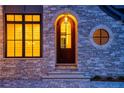 Elegant arched front door with stonework and lit windows at 4215 Tattnall Run, Acworth, GA 30101