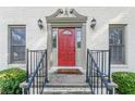 Elegant red front door with detailed trim and black railings at 303 Walnutwood Trl, Roswell, GA 30075