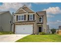 Tan two-story house with a white garage door and landscaped lawn at 242 Eva Ne Way, Cartersville, GA 30121