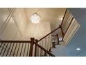 View of a grand staircase with a crystal chandelier and ornate wood railing at 10785 Arlington Pt, Alpharetta, GA 30022