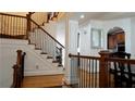 Elegant staircase with wrought iron railing and hardwood flooring, overlooking the dining area at 10785 Arlington Pt, Alpharetta, GA 30022