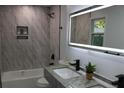 Modern bathroom with double vanity, LED mirror, and marble-look tile at 257 E Simon Nw Ter, Atlanta, GA 30318