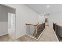 Upper hallway with carpeted flooring, showing access to bedrooms and laundry room at 255 Arwen Dr, Mcdonough, GA 30252