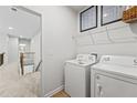 Laundry room with washer, dryer, and overhead shelving, located near bedrooms at 255 Arwen Dr, Mcdonough, GA 30252