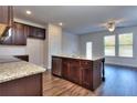 Spacious kitchen with an island, granite countertops, and dark wood cabinets at 6104 Ripple Way # 50, South Fulton, GA 30349