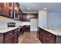Modern kitchen featuring dark wood cabinets, granite countertops, and stainless steel appliances at 6104 Ripple Way # 50, South Fulton, GA 30349