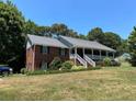 Brick ranch home with large covered porch and mature trees at 410 Kilcrease Rd, Auburn, GA 30011