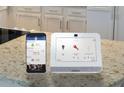 Image of a smart home security system with touchscreen panel and mobile app at 1718 Lacebark Elm Way, Lawrenceville, GA 30045