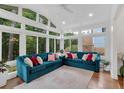 Sunroom with teal sofas and abundant natural light at 205 Lakeside Pl, Canton, GA 30114