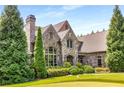 Stone and brick home with lush landscaping, showcasing the side yard at 56 Mount Paran Rd, Atlanta, GA 30327