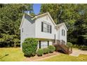 Two-story house with white siding, brown stairs, and landscaping at 3440 Homeward Trl, Ellenwood, GA 30294