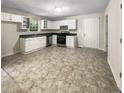 Bright kitchen with white cabinets, stainless steel appliances, and tile flooring at 101 Dodd St, Fairburn, GA 30213
