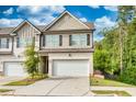 Two-story townhome with attached garage and landscaping at 5586 Cannonade Ln, Stonecrest, GA 30058