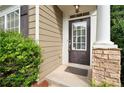 House entrance with dark door, stone pillars, and landscaping at 320 Pintail Ct, Suwanee, GA 30024
