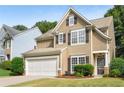 Two-story house with tan siding, white garage door, and dark shutters at 320 Pintail Ct, Suwanee, GA 30024