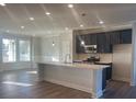 Modern kitchen featuring a large island, stainless steel appliances, and hardwood floors at 2404 Anhinga Dr, Loganville, GA 30052