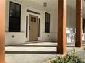 Front porch with wooden columns, white brick, and a modern light fixture at 408 Autry St, Norcross, GA 30071