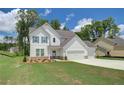 Two-story white house with gray roof, two-car garage, and landscaped lawn at 2 Lisa Ct, Moreland, GA 30259