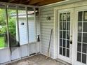 Small screened porch with damaged screen and old broom at 126 Irvin St, Jonesboro, GA 30236