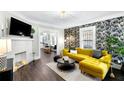 Bright living room with yellow sectional sofa, fireplace, and hardwood floors at 976 Washington St, Atlanta, GA 30315
