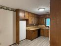 Galley-style kitchen with wood cabinets and linoleum flooring at 1799 Brandy Woods Se Trl, Conyers, GA 30013