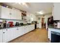 Bright eat-in kitchen with white cabinets, granite countertops, and wood-look flooring at 376 Cattlemans Cir, Mcdonough, GA 30252