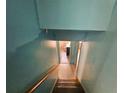 Indoor stairs leading to lower level with teal walls at 8347 Hilltop Rd, Jonesboro, GA 30236
