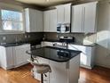 Kitchen with white cabinets, granite island, and hardwood floors at , Atlanta, GA 30318