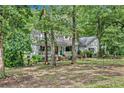 Ranch style home with wrap-around porch, surrounded by mature trees at 2841 Upper Sweetwater Se Trl, White, GA 30184