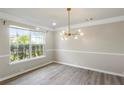 Dining room with a modern chandelier, neutral walls, and wood-look floors at 3385 Amhurst Pkwy, Atlanta, GA 30349