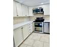 Updated kitchen with white cabinets, stainless steel appliances, and tile floors at 307 Lakemoore Ne Dr # D, Atlanta, GA 30342