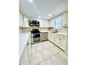 Updated kitchen with white cabinets, stainless steel appliances, and tile floors at 307 Lakemoore Ne Dr # D, Atlanta, GA 30342