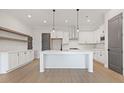 Modern kitchen with white cabinets, island, and wood floors at 945 Willingham Dr # 3, Hapeville, GA 30354