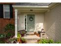 Inviting front entry with light brick facade, landscaping, and a charming green door at 1855 Barrington Overlook, Marietta, GA 30066