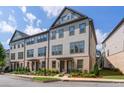 Three-story beige townhouse with gray accents and landscaping at 3701 Allegretto Cir, Atlanta, GA 30339