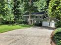 Two-story green house with a two car garage and large front yard at 4108 John Alden Ct, Stone Mountain, GA 30083