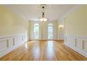 Formal dining room with hardwood floors, wainscoting, and large windows at 1357 Baniff Ct, Snellville, GA 30078